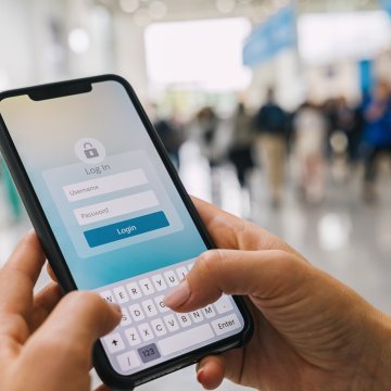 identity guard mobile app holding smartphone in hands logging 